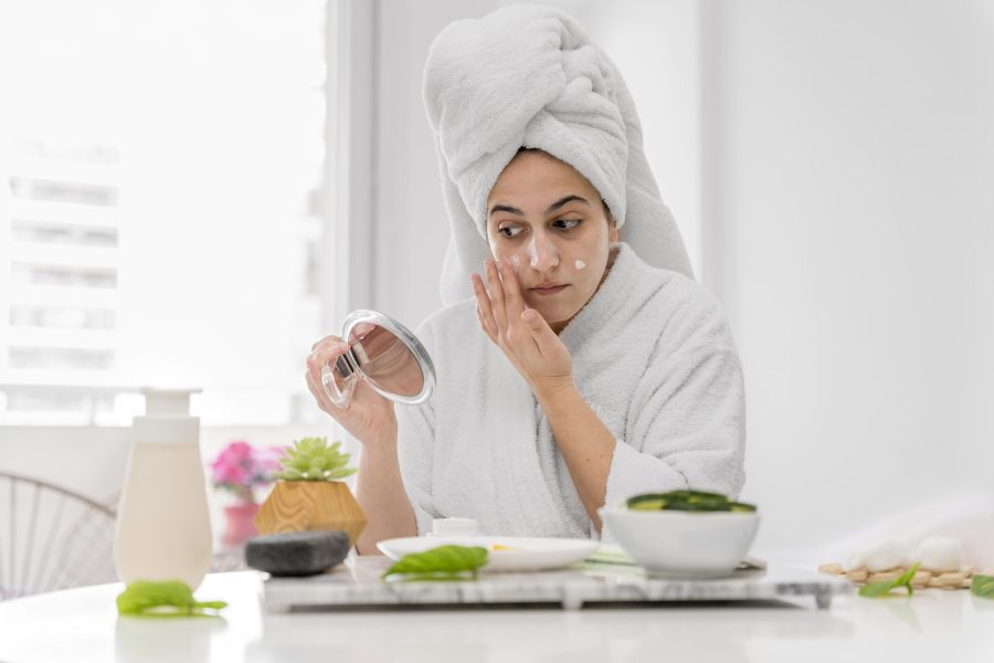 front-view-woman-applying-face-cream